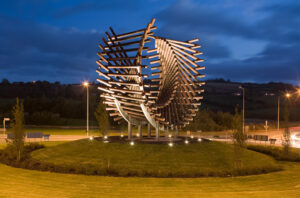 Image of an art piece in a roundabout, at night. 
