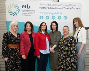 Group of people standing in front of a banner. 