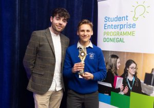 Teacher and student holding a trophy.